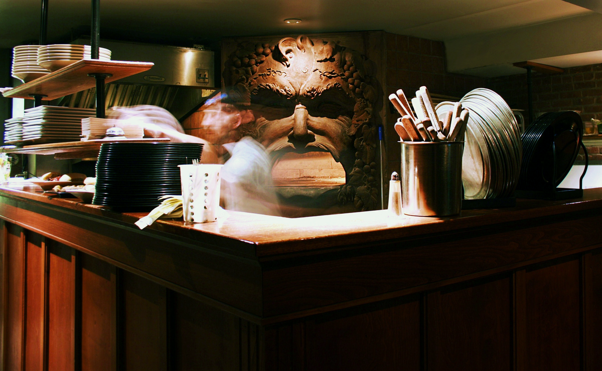 Chef working at the famous Bacchus face wood-fired oven